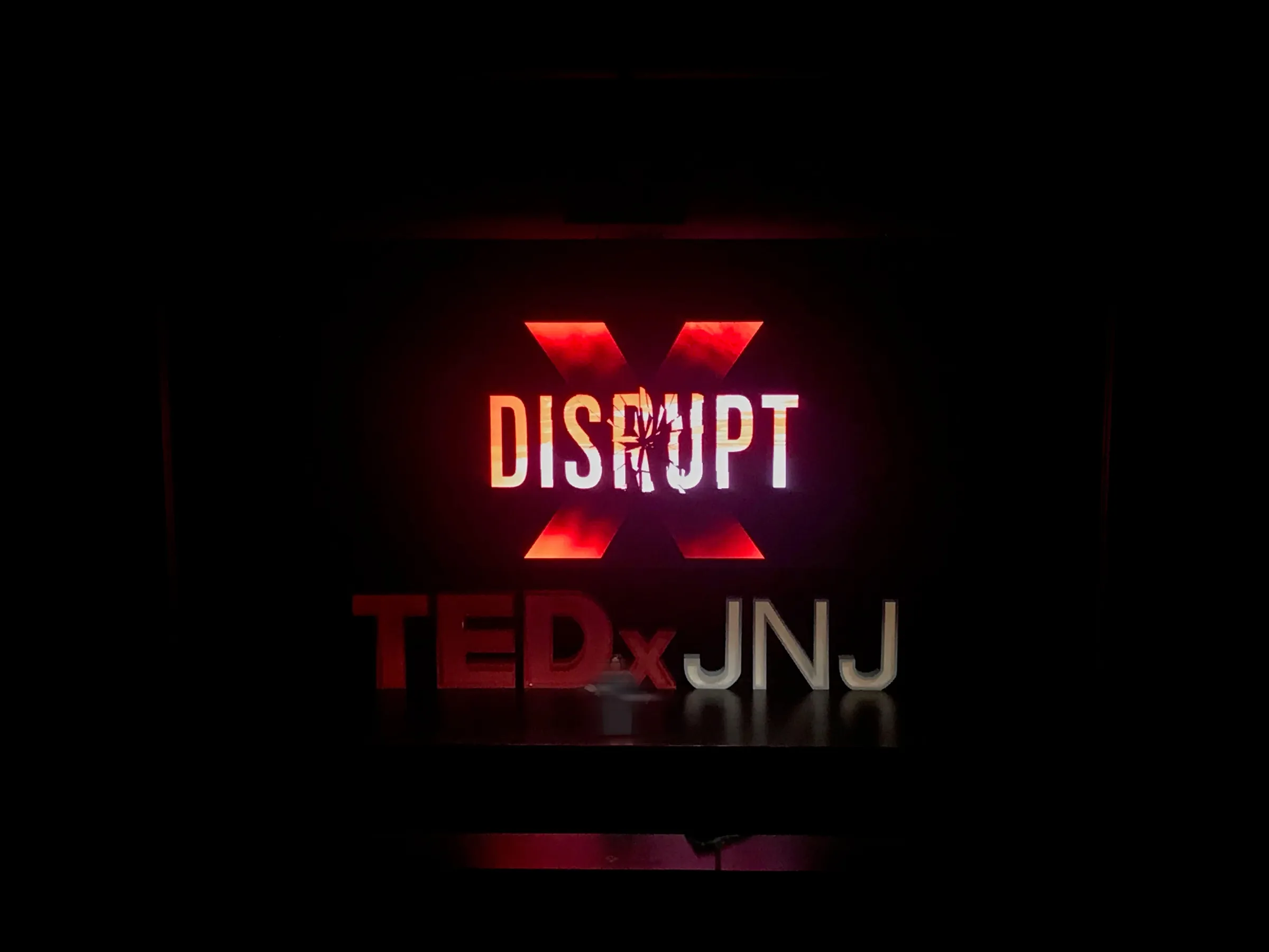 The Disrupt logo glowing on the screen at the event venue